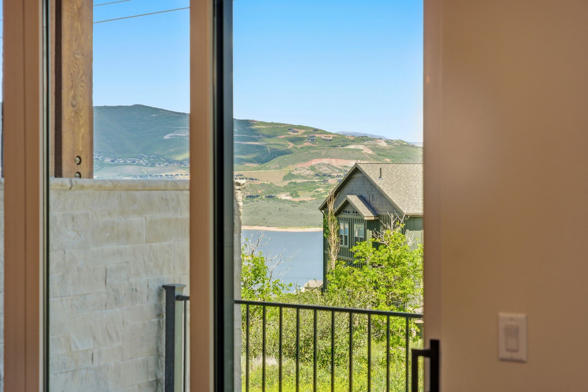 Sliding glass door opening to a balcony with black metal railing