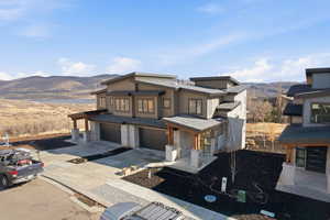 Contemporary house featuring a mountain view, concrete driveway, board and batten siding, and a garage