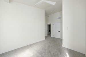 Empty room with a high ceiling and carpet floors