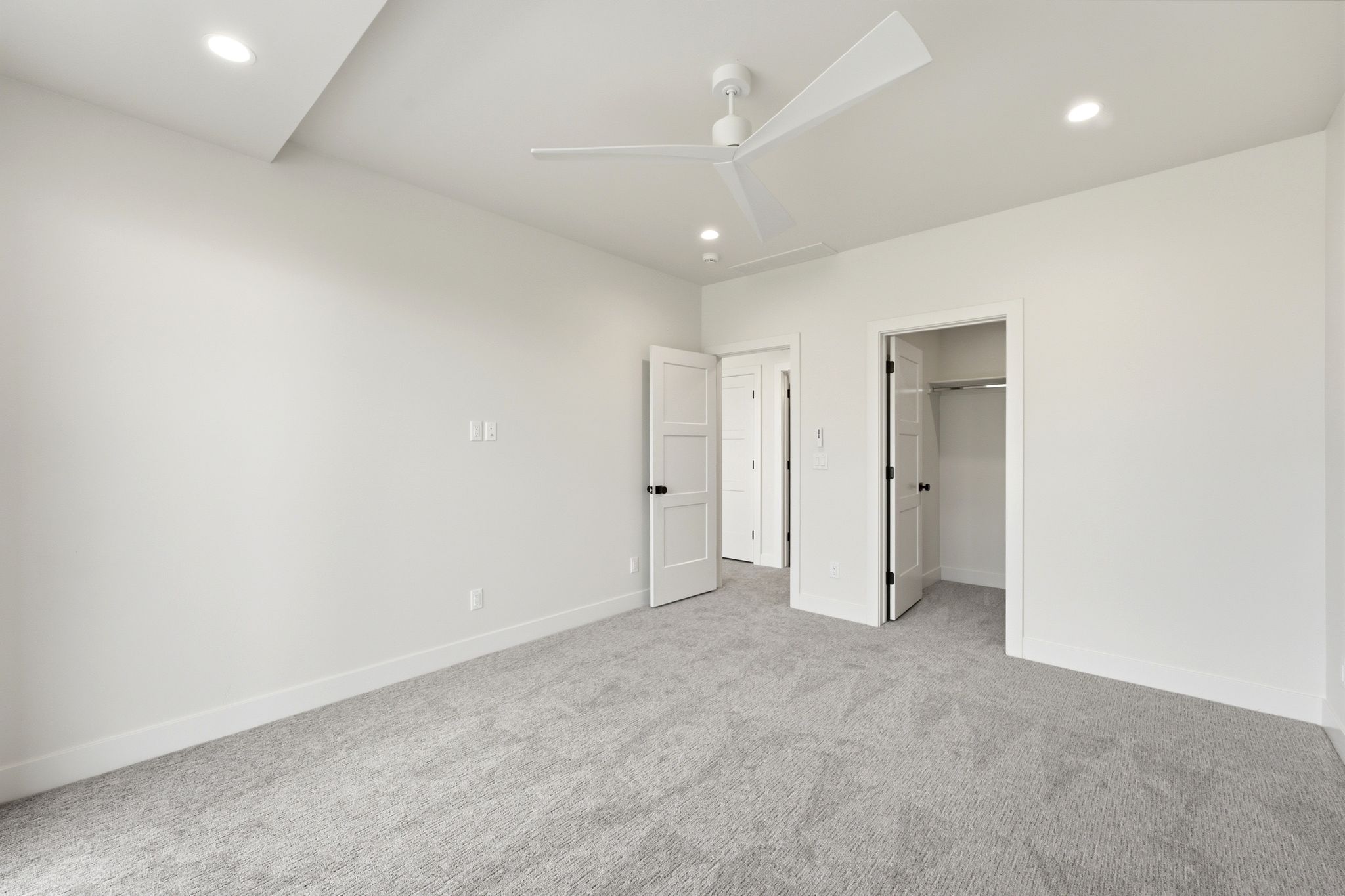 Carpeted room featuring a modern ceiling fan, recessed lighting, and white trim