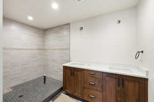 Bathroom featuring double vanity, recessed lighting, and a stall shower