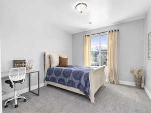 Carpeted bedroom with baseboards and visible vents