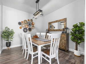 Dining space featuring wood finished floors, baseboards, and an inviting chandelier
