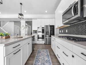 Kitchen with recessed lighting, light countertops, a sink, tasteful backsplash, and appliances with stainless steel finishes