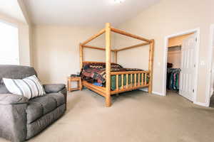 #1 Large bedroom featuring a spacious closet and warm carpeted floors.
