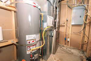Utility room featuring gas water heater, Gas central Furnace  and electric panel