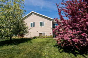 Rear view of property with a yard
