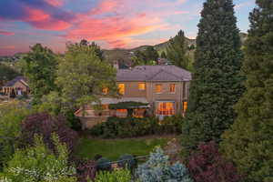 Back of house featuring a chimney, fence, a tiled roof, stucco siding, and a mountain view