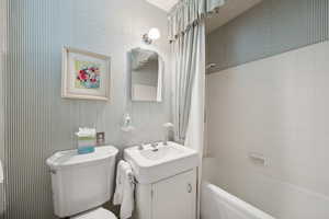 Full bath featuring toilet, vanity, and washtub / shower combination