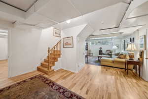 Living area with baseboards, wood finished floors, and stairs