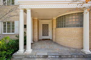 Doorway to property featuring brick siding