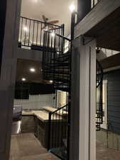 Staircase featuring a ceiling fan and brick floor