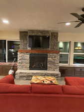 Living room featuring a ceiling fan and a fireplace