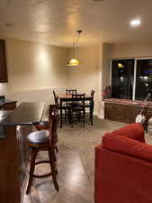 Carpeted living area featuring recessed lighting, a textured ceiling, and baseboards