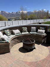 View of patio / terrace with a fenced backyard, a fire pit, and a mountain view