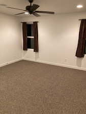 Spare room featuring recessed lighting, dark carpet, baseboards, and ceiling fan
