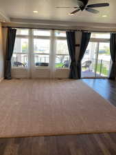 Empty room featuring plenty of natural light, a ceiling fan, and wood finished floors
