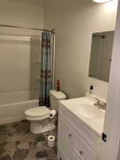 Bathroom with shower / tub combo, toilet, and vanity
