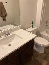 Full bathroom featuring toilet, vanity, and  shower combination