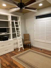 Unfurnished room with visible vents, a ceiling fan, baseboards, and dark wood-style flooring