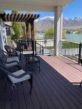 Wooden terrace featuring a pergola and a water and mountain view