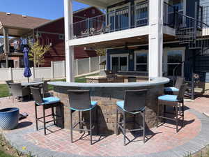 View of patio featuring fence, outdoor wet bar, and area for grilling