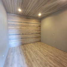 Unfurnished room featuring wood finished floors, wooden ceiling, wood walls, and recessed lighting