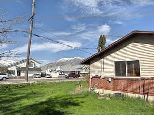 View of home's exterior featuring a lawn, brick siding, and a mountain view