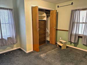Unfurnished bedroom with carpet, visible vents, and baseboards