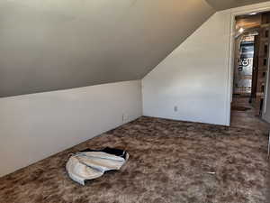 Bonus room featuring lofted ceiling and carpet