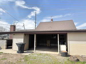 Back of property with brick siding, a patio area, and a chimney