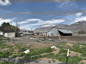 View of yard featuring an outbuilding, fence, and a mountain view