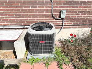 Exterior details with cooling unit and brick siding