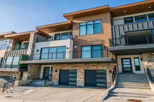 View of property with an attached garage, driveway, and entry steps