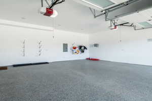 Garage featuring electric panel and a garage door opener