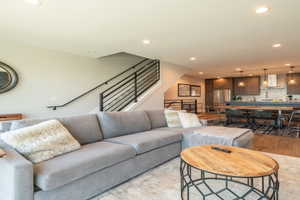 Living area featuring stairs, light wood finished floors, and recessed lighting