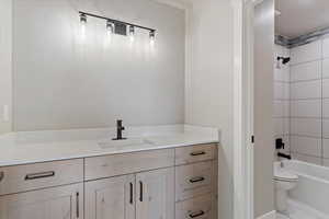 Bathroom with marble finish floor, toilet, shower / bathing tub combination, and vanity
