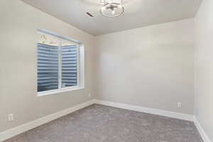 Carpeted spare room with baseboards and a textured ceiling