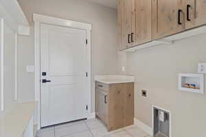 Washroom with washer hookup, electric dryer hookup, marble finish floor, baseboards, and cabinet space