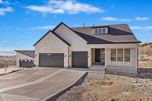 View of front facade featuring brick siding, driveway, and a garage
