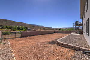 View of yard with a fenced backyard, stairs, and a mountain view