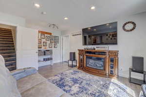 Living area with recessed lighting, wood finished floors, and stairs