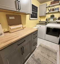 Laundry area with washer and dryer, cabinet space, and light wood-type flooring