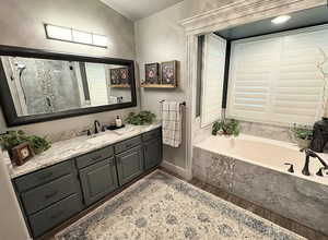 Full bath with wood finished floors, a garden tub, vanity, and a stall shower