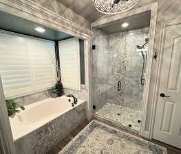 Full bathroom with a garden tub, wood finished floors, and a stall shower
