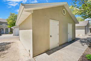 View of outbuilding with driveway and a garage