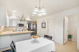 Dining space featuring recessed lighting, a chandelier, light tile patterned floors, baseboards, and visible vents