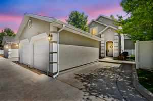 View of front of home featuring an attached garage and stucco siding