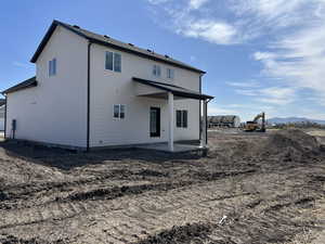 Back of property with a mountain view and a patio