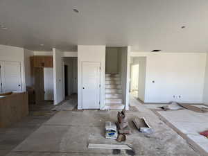 Unfurnished living room with stairs